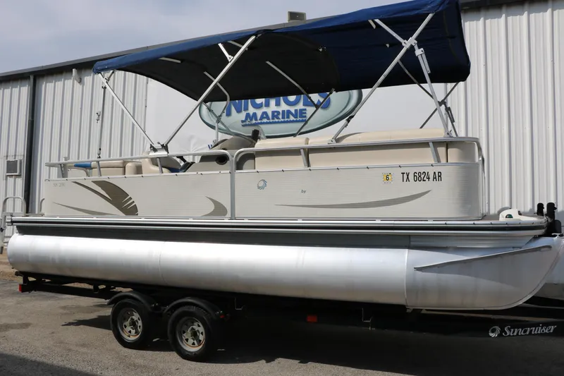 Slide: The Image of 2008 Sun Cruiser SS200 pontoon boat with canopy on trailer, parked outside marine shop. - 2