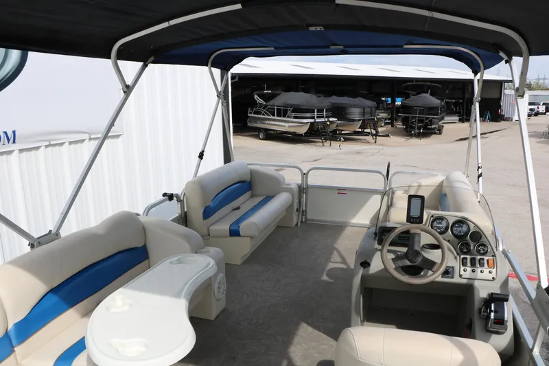 Slide: The Image of 2008 Sun Cruiser SS200 pontoon boat interior with seating and steering console, docked near other boats. - 20