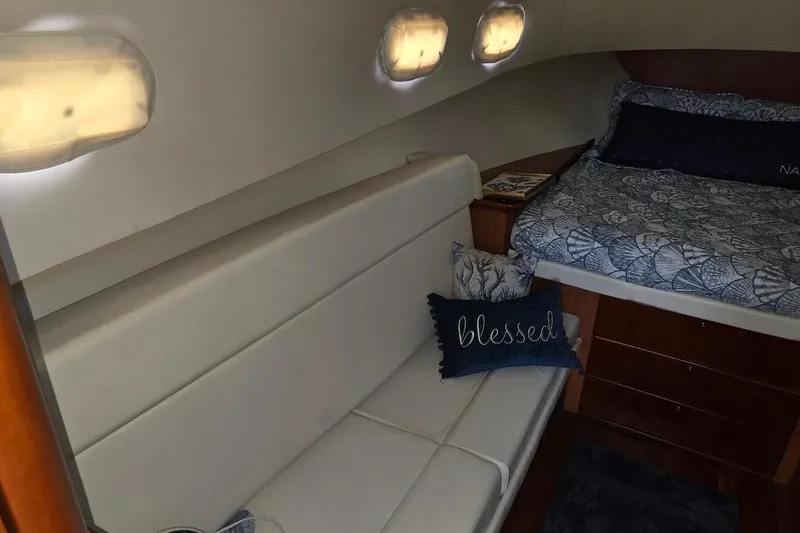 Slide: The Image of 2009 Mainship Pilot 31 cabin interior with cozy seating and bed. - 13