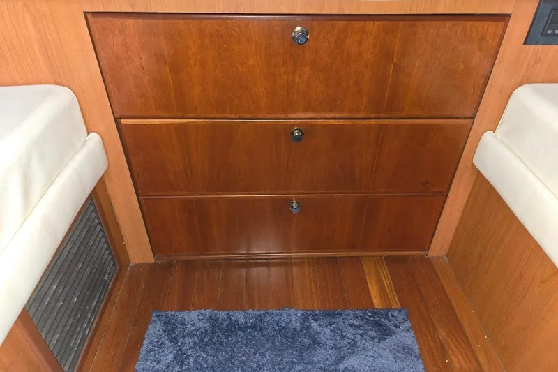 Slide: The Image of Interior of 2009 Mainship Pilot 31 with wooden drawers and blue rug. - 15