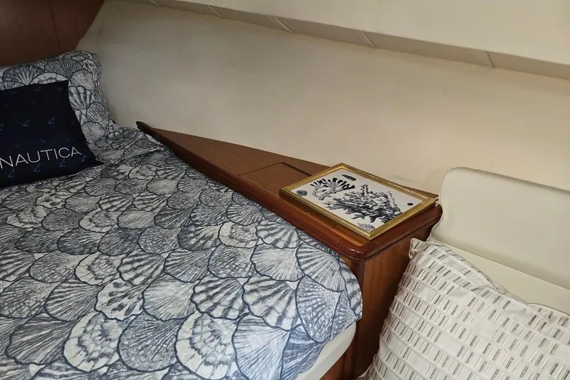 Slide: The Image of Cozy cabin interior of 2009 Mainship Pilot 31 with nautical-themed bedding and decor. - 18
