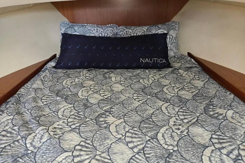 Slide: The Image of Cozy cabin bed in 2009 Mainship Pilot 31 boat with patterned bedding and Nautica pillow. - 19
