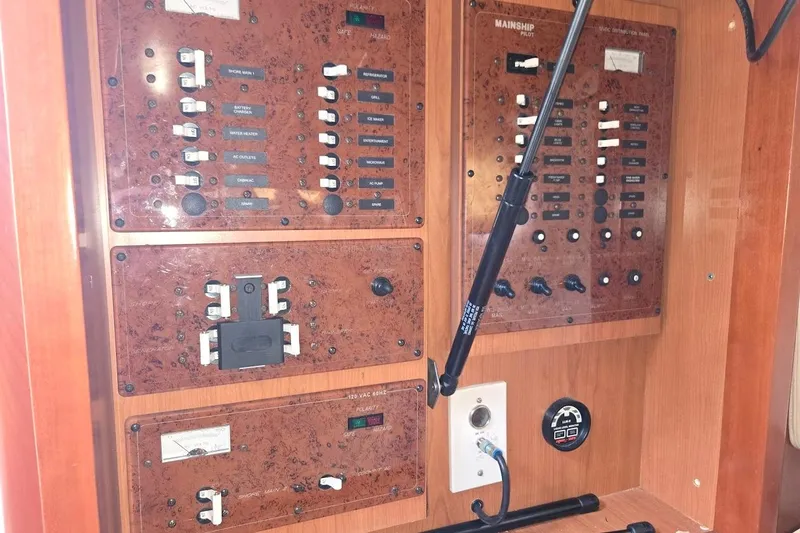 Slide: The Image of Electrical control panel of 2009 Mainship Pilot 31 boat, featuring switches and gauges. - 23