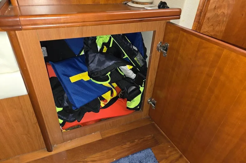 Slide: The Image of Open cabinet on 2009 Mainship Pilot 31 boat, storing colorful life jackets. - 26