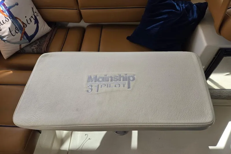 Slide: The Image of 2009 Mainship Pilot 31 interior with cushioned table and nautical-themed decor. - 30