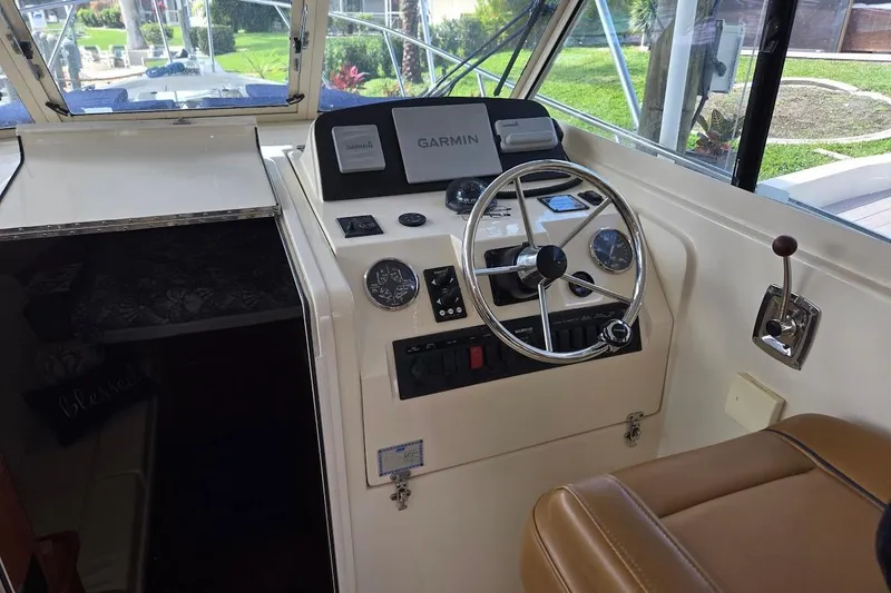 Slide: The Image of 2009 Mainship Pilot 31 helm with Garmin navigation, steering wheel, and control panel. - 32