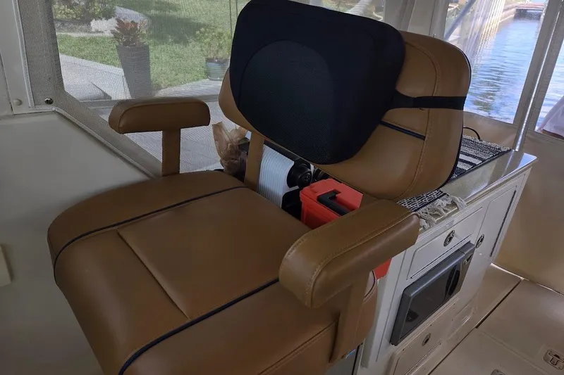 Slide: The Image of Captain's chair on 2009 Mainship Pilot 31 boat, featuring tan upholstery and armrests. - 34