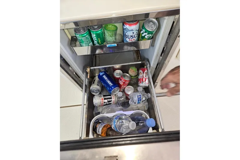 Slide: The Image of Refrigerator stocked with drinks on a 2009 Mainship Pilot 31 boat. - 36