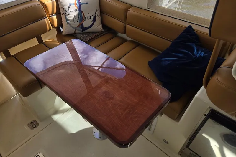 Slide: The Image of Interior of 2009 Mainship Pilot 31 with wooden table and cushioned seating. - 4