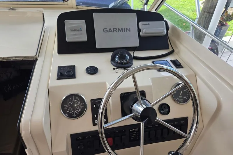 Slide: The Image of 2009 Mainship Pilot 31 helm with Garmin navigation, compass, and control gauges. - 40