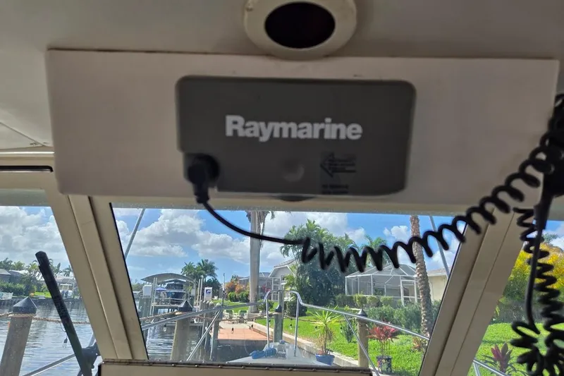 Slide: The Image of 2009 Mainship Pilot 31 boat with Raymarine equipment, docked near a scenic waterfront. - 50
