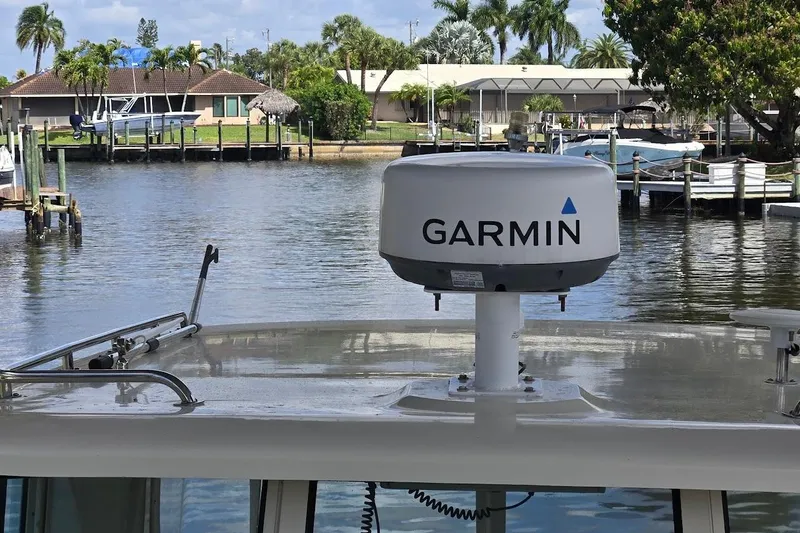 Slide: The Image of 2009 Mainship Pilot 31 with Garmin radar, docked in a scenic waterfront setting. - 63