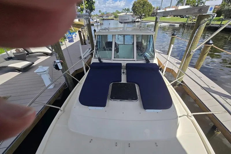 Slide: The Image of 2009 Mainship Pilot 31 docked, featuring a spacious deck with blue cushions. - 7