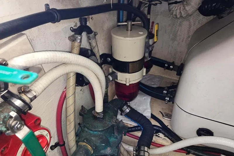 Slide: The Image of Engine compartment of a 2009 Mainship Pilot 31 with visible hoses and filter system. - 75