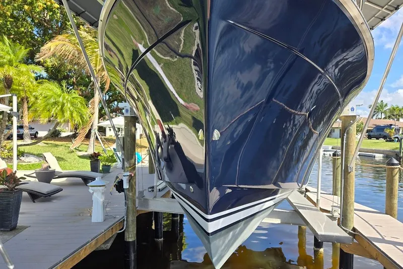 Slide: The Image of 2009 Mainship Pilot 31 boat docked, reflecting sunlight, surrounded by tropical greenery. - 8
