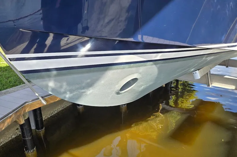 Slide: The Image of 2009 Mainship Pilot 31 boat hull with blue and white stripes, docked above water. - 9