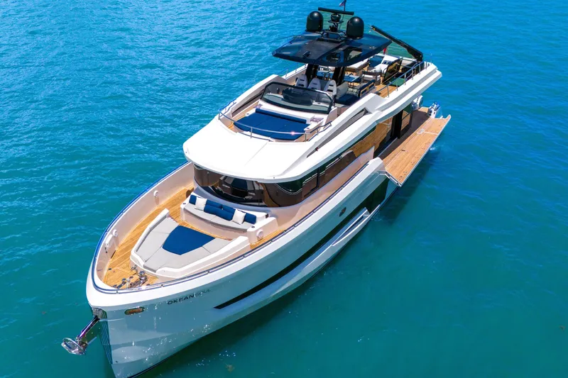 Slide: The Image of Luxury 2021 OKEAN 80 yacht cruising on clear blue water. - 10