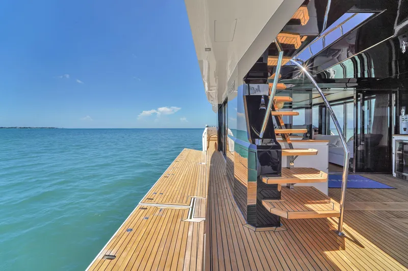 Slide: The Image of Luxurious 2021 OKEAN 80 yacht with elegant wooden deck and modern staircase, overlooking serene ocean. - 12
