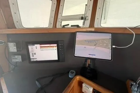 Slide: The Image of Navigation equipment inside a 2001 Nordhavn 40 boat, featuring digital displays and a tablet. - 12
