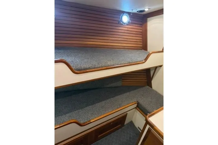 Slide: The Image of Bunk beds in 2001 Nordhavn 40 yacht cabin with wooden paneling and porthole. - 16