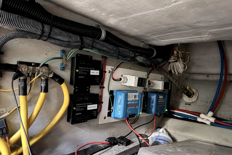 Slide: The Image of Electrical system setup in a 2001 Nordhavn 40 boat, featuring wiring and charge controllers. - 21