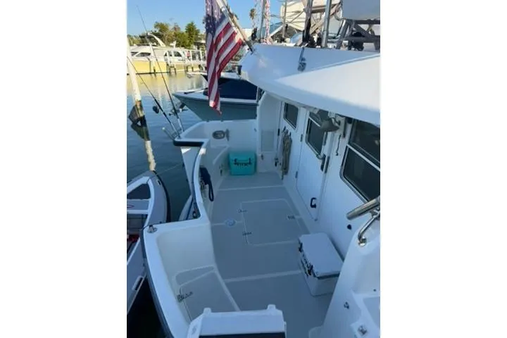 Slide: The Image of 2001 Nordhavn 40 yacht docked, featuring spacious deck and American flag. - 23