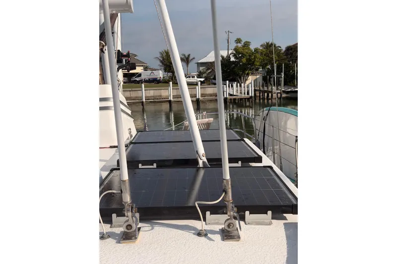 Slide: The Image of 2001 Nordhavn 40 yacht with solar panels on deck, docked near waterfront homes. - 25