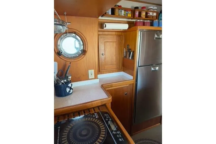 Slide: The Image of Kitchen area of a 2001 Nordhavn 40 yacht with wooden cabinetry and stainless steel appliances. - 9