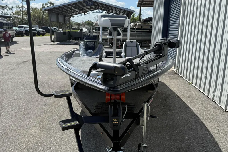 Slide: The Image of 2025 Phoenix 819 ZXL boat with Lowrance equipment, parked outdoors near a metal building. - 11