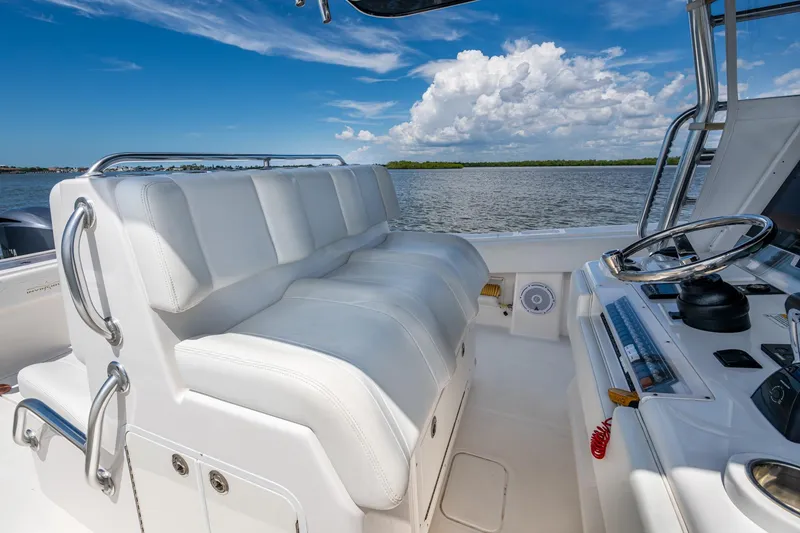 Slide: The Image of 2015 Invincible 42 Open Fisherman boat interior with white seating and steering wheel. - 11