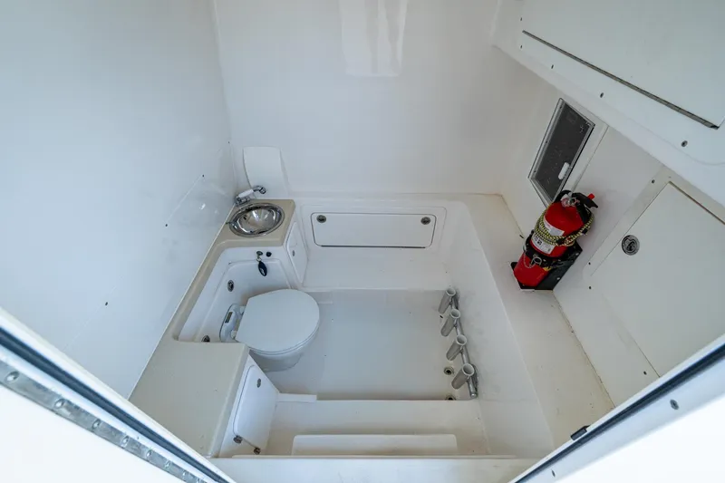 Slide: The Image of 2015 Invincible 42 Open Fisherman boat interior with toilet, sink, and fire extinguisher. - 14