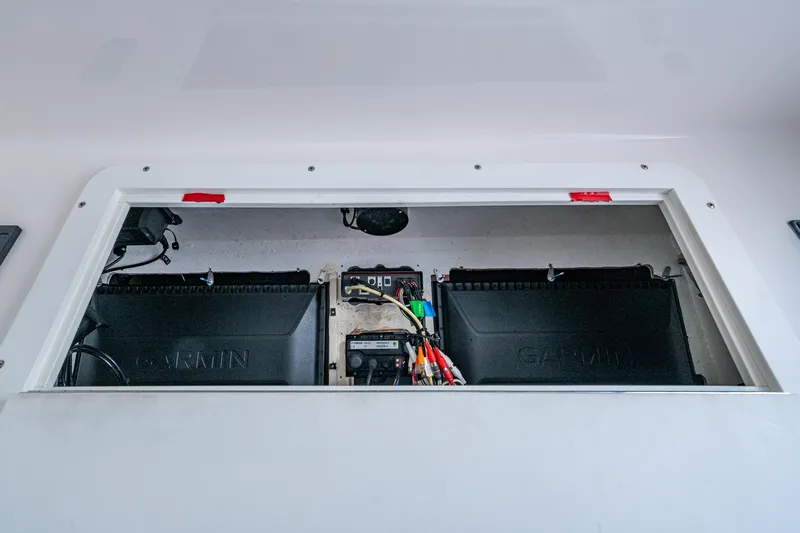 Slide: The Image of 2015 Invincible 42 Open Fisherman electronics compartment with Garmin equipment and wiring. - 15
