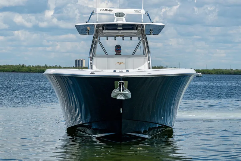 Slide: The Image of 2015 Invincible 42 Open Fisherman boat on calm water, front view, clear sky background. - 2