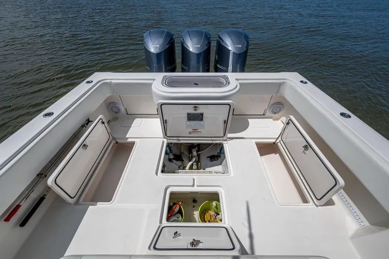 Slide: The Image of 2015 Invincible 42 Open Fisherman boat deck with storage compartments and triple engines. - 20