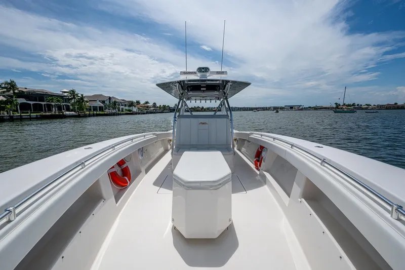 Slide: The Image of 2015 Invincible 42 Open Fisherman boat on calm waters, clear sky, and coastal backdrop. - 23