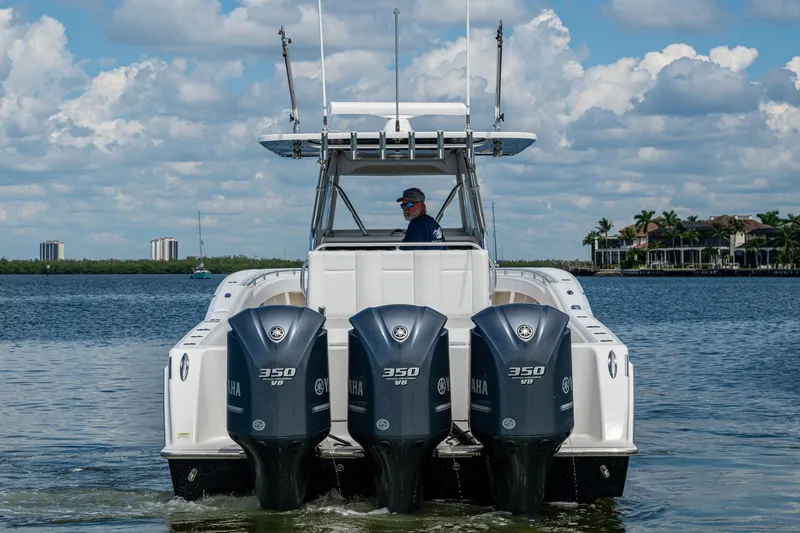 Slide: The Image of 2015 Invincible 42 Open Fisherman with triple Yamaha 350 V8 engines on calm water. - 4