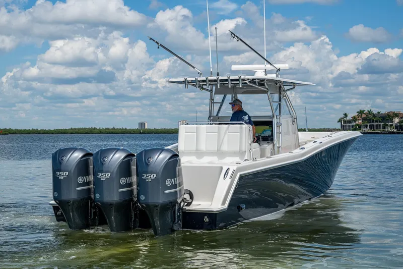 Slide: The Image of 2015 Invincible 42 Open Fisherman boat with four Yamaha 350 engines on calm water. - 5