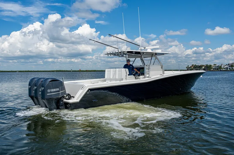 Slide: The Image of 2015 Invincible 42 Open Fisherman boat cruising on calm waters under a blue sky. - 6