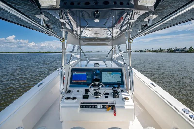 Slide: The Image of 2015 Invincible 42 Open Fisherman boat dashboard with navigation screens on open water. - 9