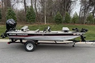 Slide: The Image of 2002 Tracker Pro Team 165 boat on trailer, parked on road with trees in background. - 14