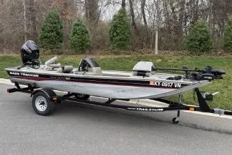 Slide: The Image of 2002 Tracker Pro Team 165 boat on trailer, parked roadside with trees in background. - 15