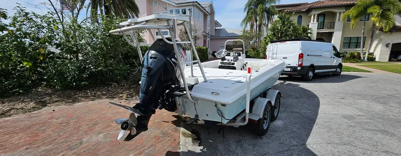 Slide: The Image of 2007 Young Boats 20 Bay on trailer, parked in residential area with palm trees. - 2