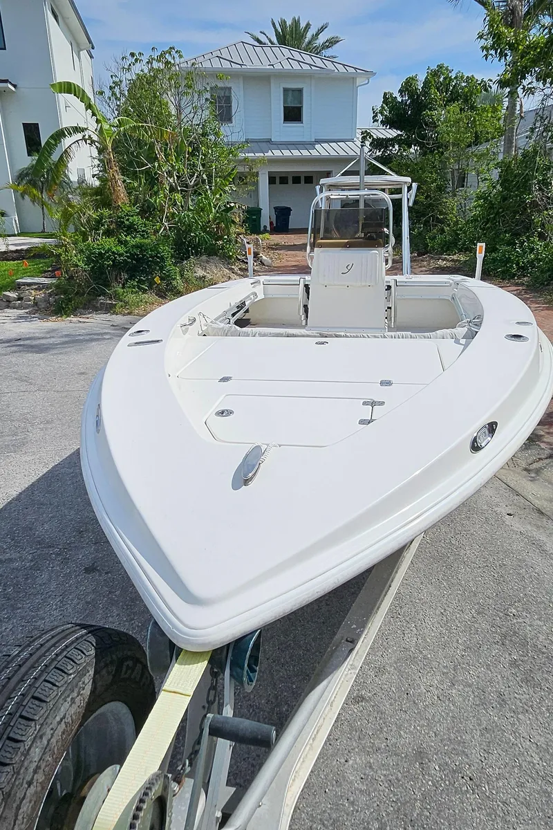 Slide: The Image of 2007 Young Boats 20 Bay on trailer, parked in residential area with greenery. - 8