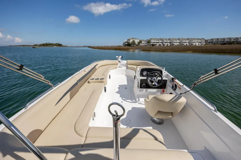 Slide: The Image of 2019 Hurricane SunDeck Sport 201 OB boat on calm water, featuring spacious seating and steering console. - 10