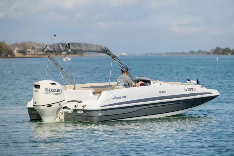 Slide: The Image of 2019 Hurricane SunDeck Sport 201 OB boat on calm water with Suzuki outboard motor. - 2