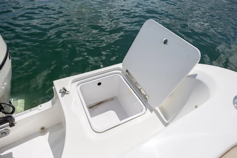Slide: The Image of Open storage compartment on 2019 Hurricane SunDeck Sport 201 OB boat by the water. - 24