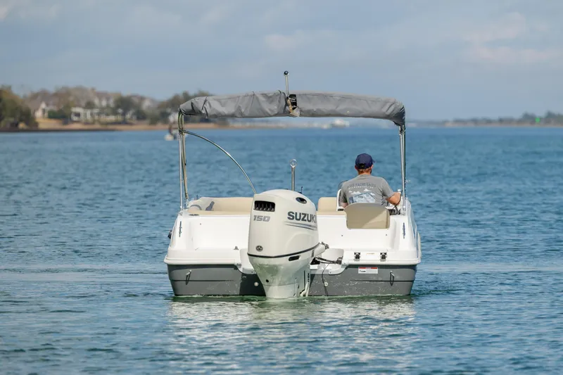 Slide: The Image of 2019 Hurricane SunDeck Sport 201 OB boat cruising on a calm lake. - 3