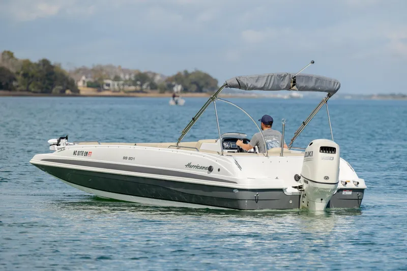 Slide: The Image of 2019 Hurricane SunDeck Sport 201 OB boat cruising on a calm lake. - 4