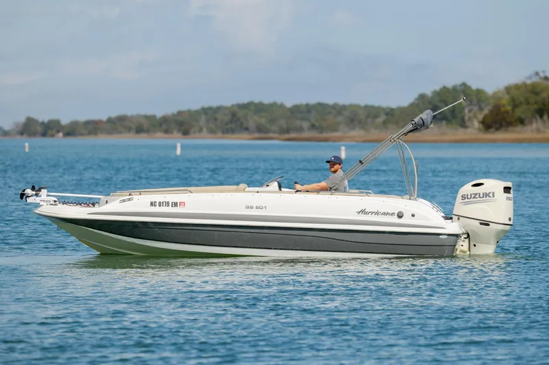 Slide: The Image of 2019 Hurricane SunDeck Sport 201 OB boat cruising on a serene lake. - 5