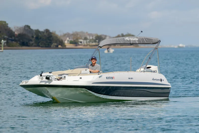 Slide: The Image of 2019 Hurricane SunDeck Sport 201 OB boat cruising on a calm lake. - 6